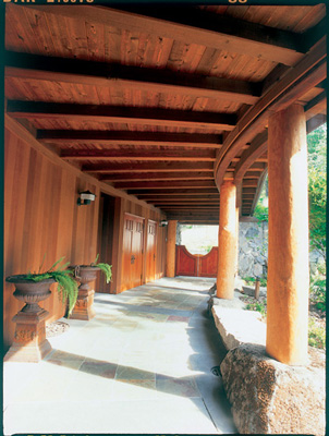 The posts supporting the entry walkway are ponderosa pine logs harvested from the property, peeled by hand with a drawknife and shaped at the bottom to fit the supporting granite boulder. A steel pin drilled into the boulder and the post assures a positive connection.